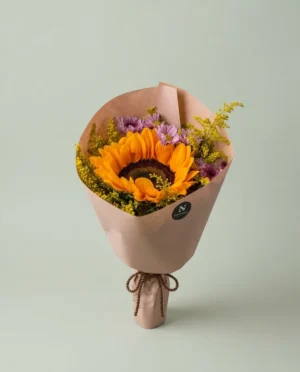Ramo de girasol radiante con margaritas y solidago envuelto en papel coreano