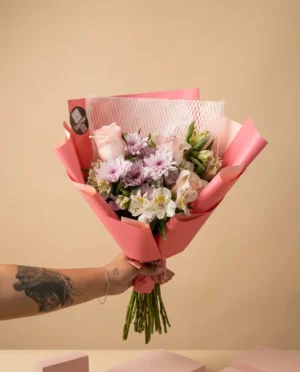 Ramo de rosas, alstroemerias y crisantemos envuelto en papel rosa