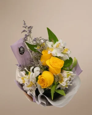 Ramo de rosas amarillas y alstroemerias envuelto en tonos lilas